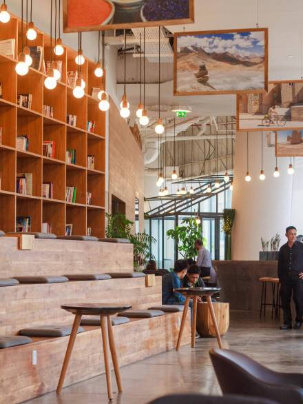 Elegant modern workspace in Ho Chi Minh City with bookshelves and pendant lighting.